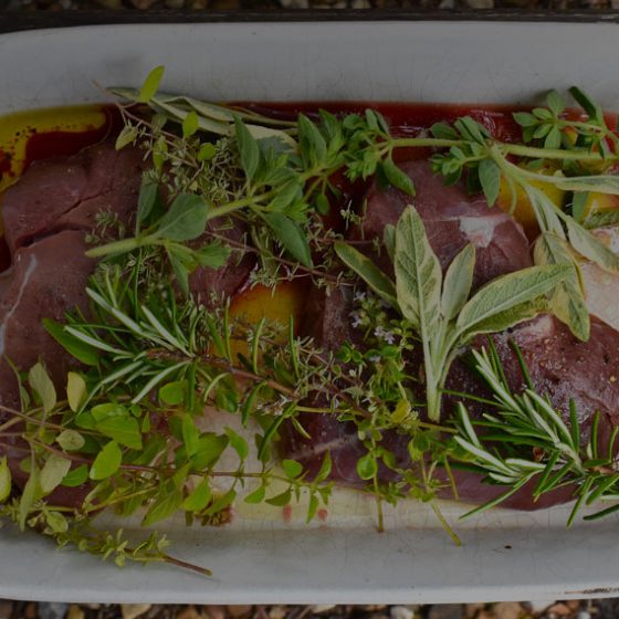 Two wild boar marinated steaks with fresh herbs